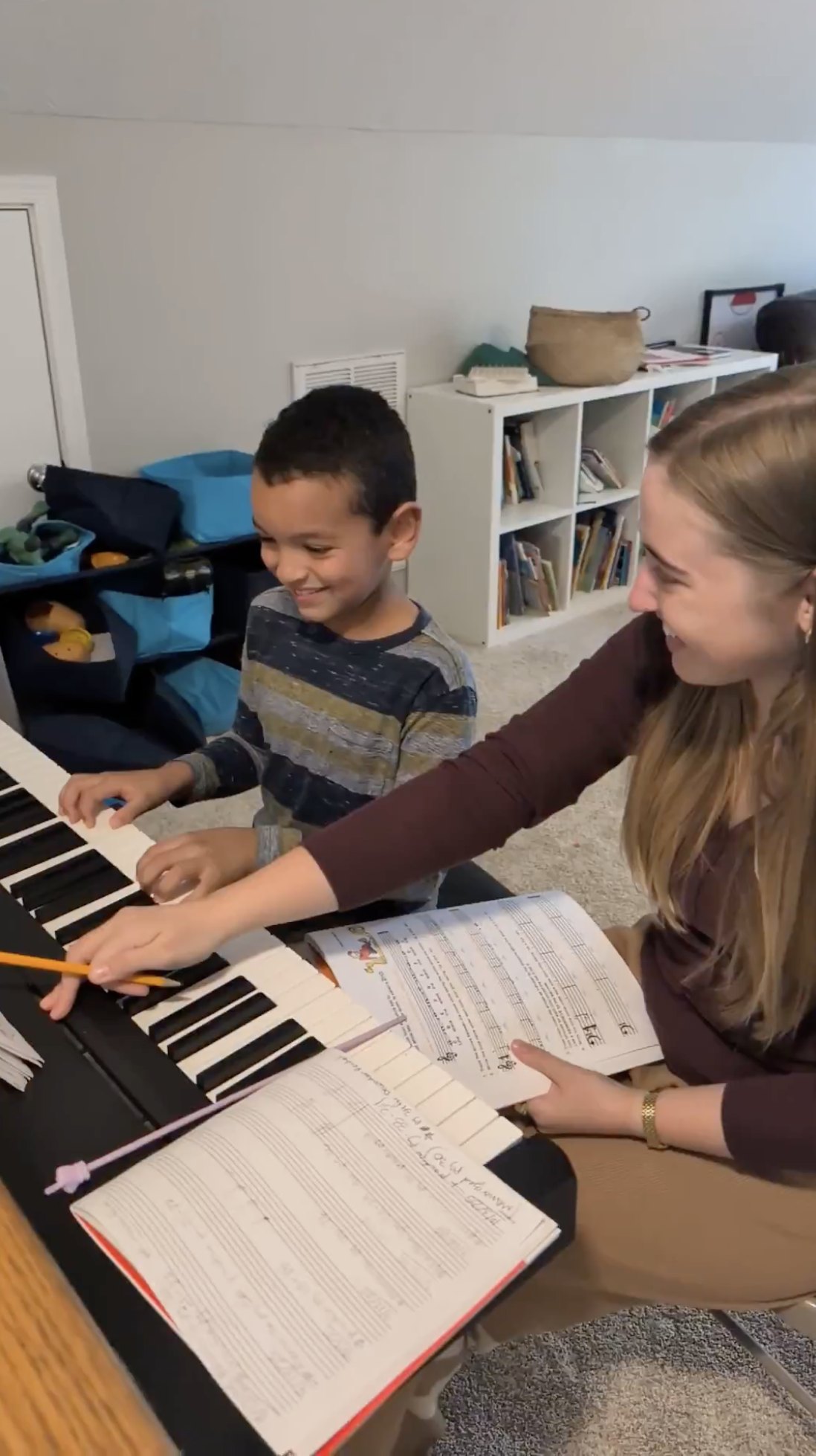 A Grace Haven teacher guiding a young student through a piano lesson at home